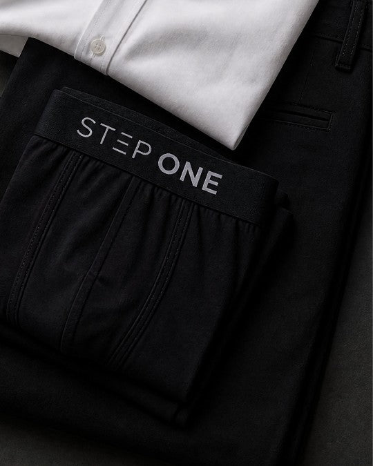 Black Step One boxer briefs folded on a white shirt and black trousers